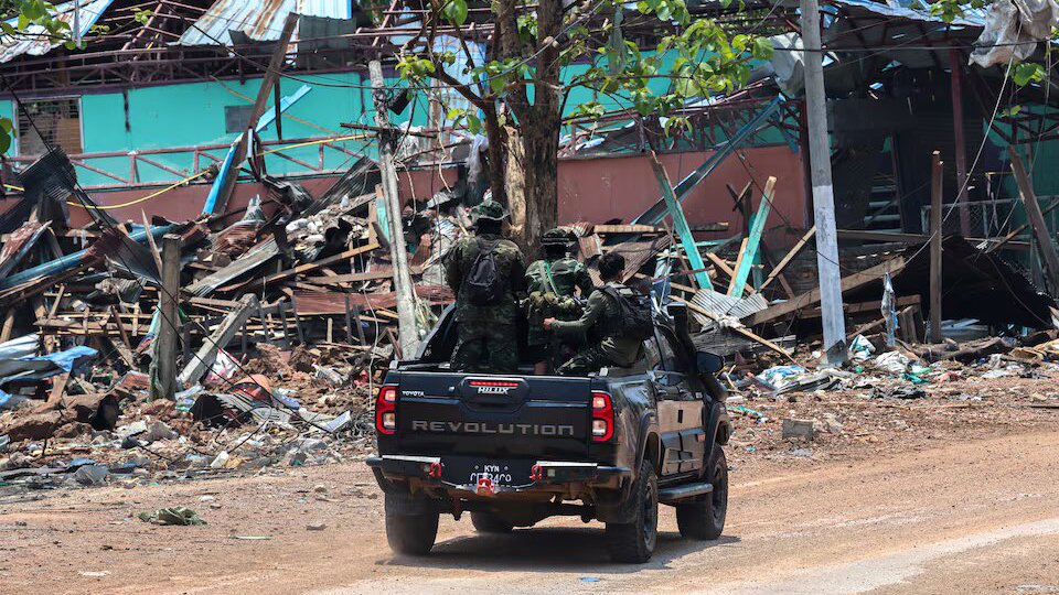 Soldiers from the Karen National Liberation Army (KNLA) patrol on a vehicle, next to an area destroyed by Myanmar's airstrike in Myawaddy, the Thailand-Myanmar border town under the control of a coalition of rebel forces led by the Karen National Union, in Myanmar, April 15, 2024. Photo: Reuters.