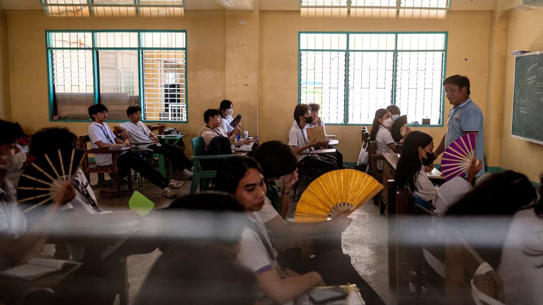 Grade 12 students use hand fans as they attend a class at the Commonwealth High School, in Quezon City, Metro Manila, Philippines, April 18, 2024. Photo: Reuters.