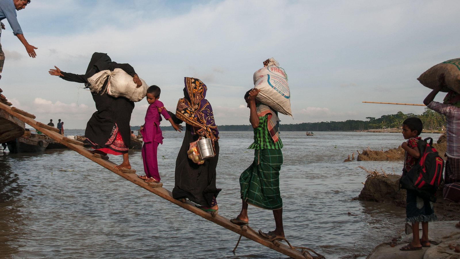 Residents of Bhola district moving towards shelter during a storm in 2014. Nearly 15 million Bangladeshis were displaced due to disasters in the last decade. (Image: Mohammad Ponir Hossain / Alamy via Dialogue Earth)