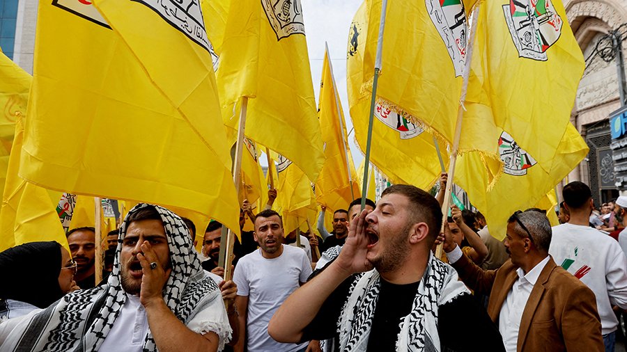 People hold Fatah flags during a protest in support of the people of Gaza, as the conflict between Israel and Palestinian Islamist group Hamas continues, in Hebron, in the Israeli-occupied West Bank, October 27, 2023. REUTERS/Mussa Qawasma/File Photo