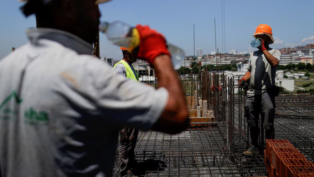 Construction workers drink water while working on a building during hot weather in Pristina, Kosovo June 19, 2024. REUTERS/Valdrin Xhemaj